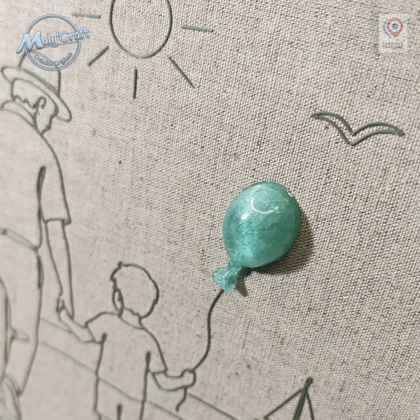 Peut inclure: Un panneau en tissu beige texturé présentant un dessin au trait gris foncé représentant un adulte et un enfant marchant ensemble. Un ballon tridimensionnel vert menthe brillant est fixé au tissu, relié à la main de l'enfant par un trait fin.