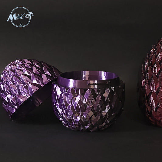 Œuf de dragon imprimé en 3D, ouvert en deux parties pour révéler l’intérieur. Les coques effet écailles sont colorées en violet et noir, avec un espace creux pour y cacher un petit objet. Boîte secrète idéale pour bijoux, surprises ou accessoires fantasy. Design unique et fabriqué en France, parfait pour cadeau geek, déco médiévale ou univers magique inspiré des dragons et sorcellerie.