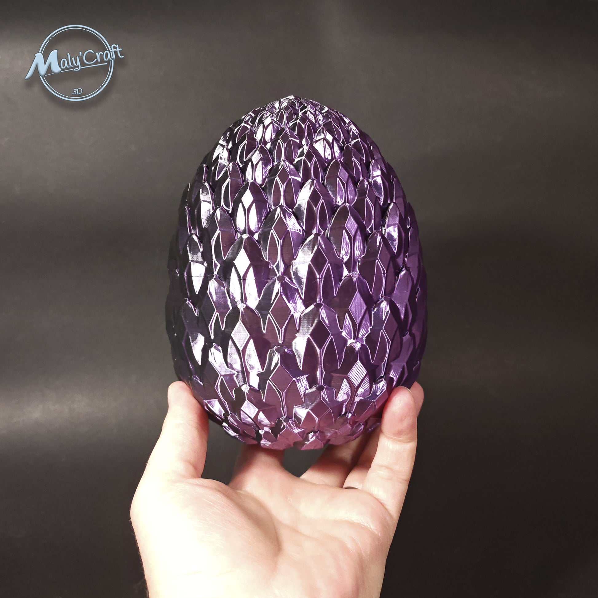 Œuf de dragon cristal violet tenu dans la main en impression 3D