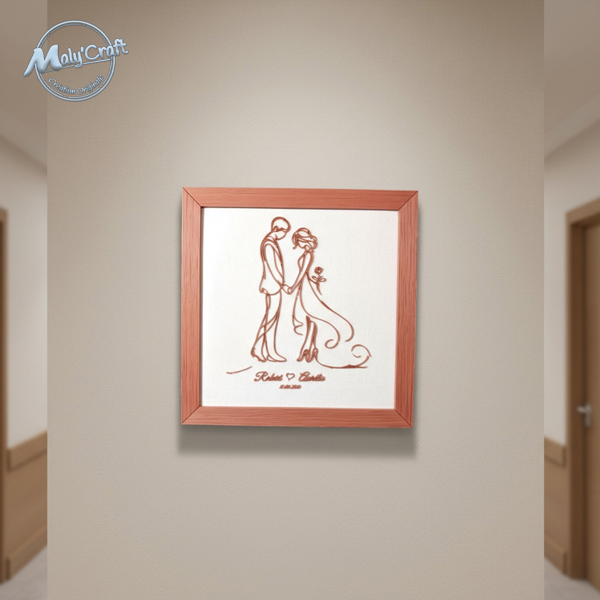 Cadre mariage terracotta sur tissu blanc accroché au mur d’un couloir. Objet décoratif artisanal de 23 x 23 cm, design filaire imprimé en 3D par Maly’Craft.