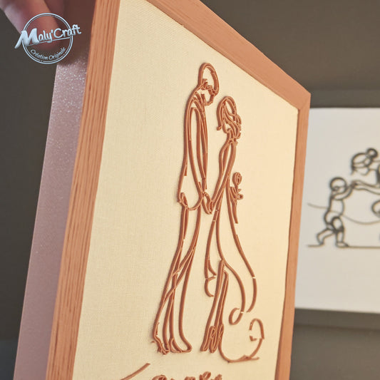 Vue rapprochée du cadre mariage Maly’Craft. Couple filaire imprimé en 3D couleur terracotta sur tissu blanc, alliance d’élégance et de douceur pour une déco artisanale.