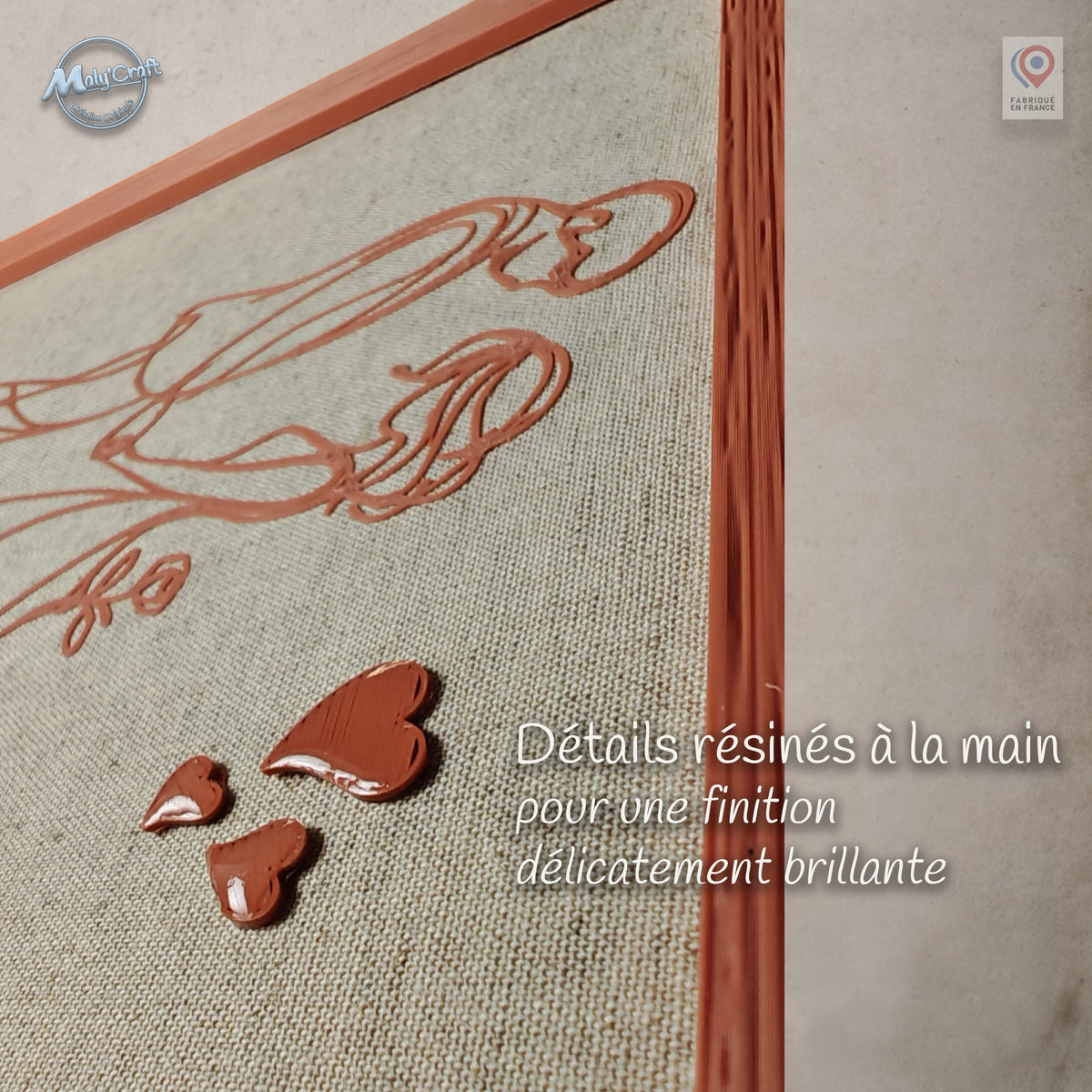 Gros plan sur les trois cœurs en relief d’un cadre de mariage personnalisé. Les cœurs sont résinés à la main pour obtenir une finition brillante qui contraste avec le dessin 3D mat imprimé sur le lin.
Close-up of three raised hearts on a personalized wedding frame. The hearts are hand-resin finished for a glossy effect that contrasts with the matte 3D printed design on the linen.
