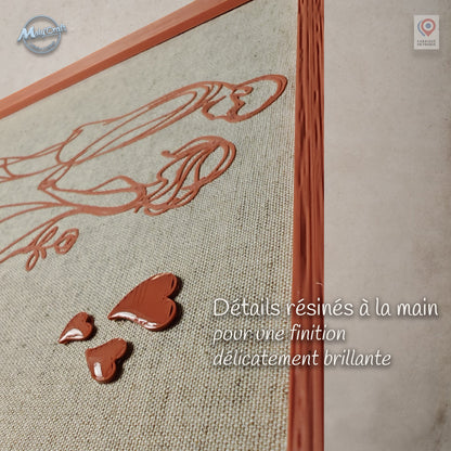 Gros plan sur les trois cœurs en relief d’un cadre de mariage personnalisé. Les cœurs sont résinés à la main pour obtenir une finition brillante qui contraste avec le dessin 3D mat imprimé sur le lin.
Close-up of three raised hearts on a personalized wedding frame. The hearts are hand-resin finished for a glossy effect that contrasts with the matte 3D printed design on the linen.