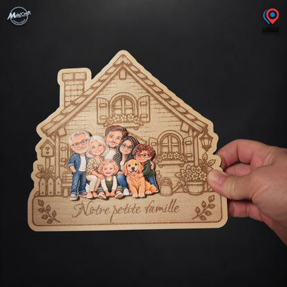 Maison de famille personnalisée photographiée dans une main sur fond noir, montrant le produit et son échelle relative. Le support en bois clair présente une façade gravée, six personnes et un chien réunis en personnages chibi colorés, ainsi que l’inscription Notre petite famille.
Photograph of a personalized wooden family house plaque held in one hand against a black background, showing the physical product and its relative scale. The engraved house features six colorful chibi people and a dog above the Fr