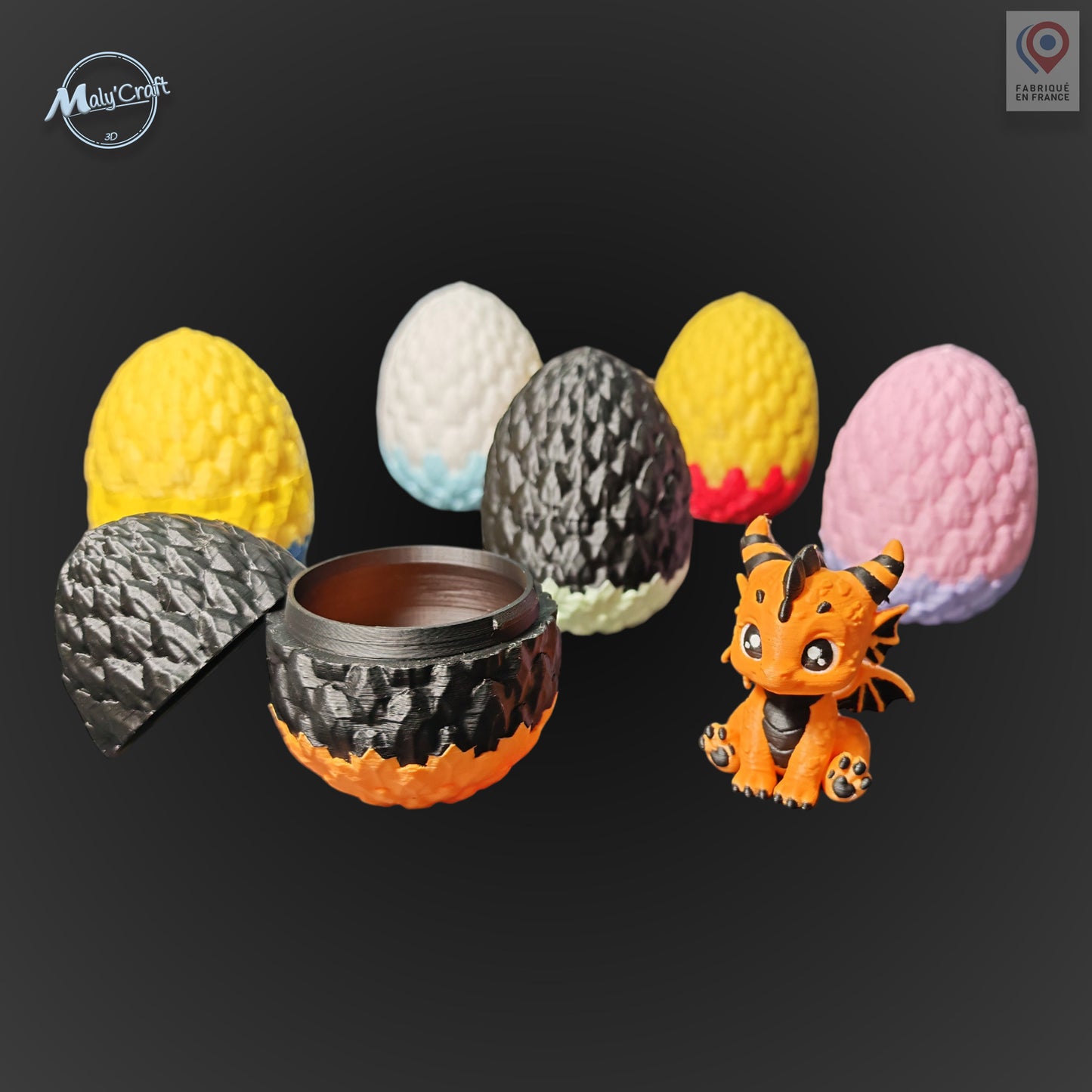 œuf bicolore noir et orange ouvert. En arrière-plan, 5 œufs de dragon disponibles en différents coloris : jaune, blanc/turquoise, noir/rouge, noir/vert et rose/violet. Figurines 3D impression de précision, création originale fabriquée en France. Œuf en deux parties emboîtables.