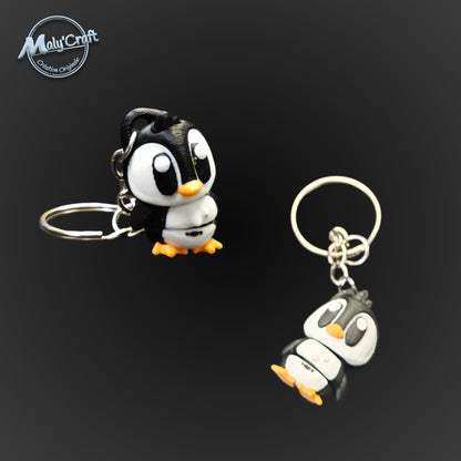 Figurines de manchots ou pinguoin en porte-clés, couleurs noir, blanc et orange, montrant une finition de