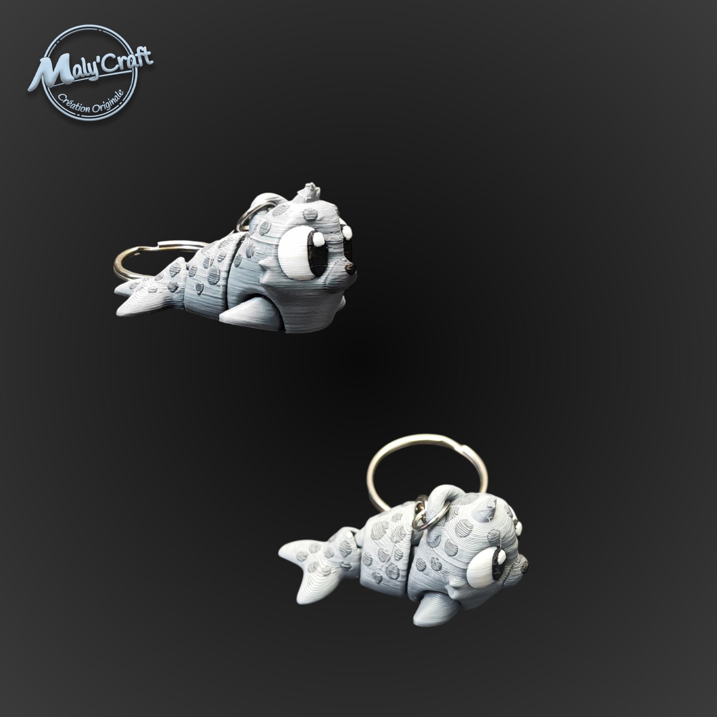 Couple de porte-clés phoques gris et blancs, design minimaliste et robuste imprimé en 3D dans notre atelier.