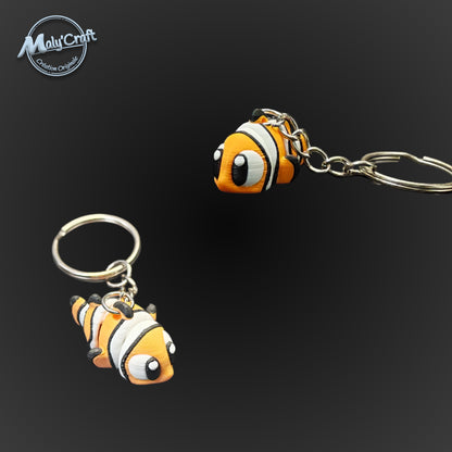 Porte-clés poissons-clowns orange et noirs rappelant Nemo, impression 3D avec des couleurs vibrantes et contrastées.